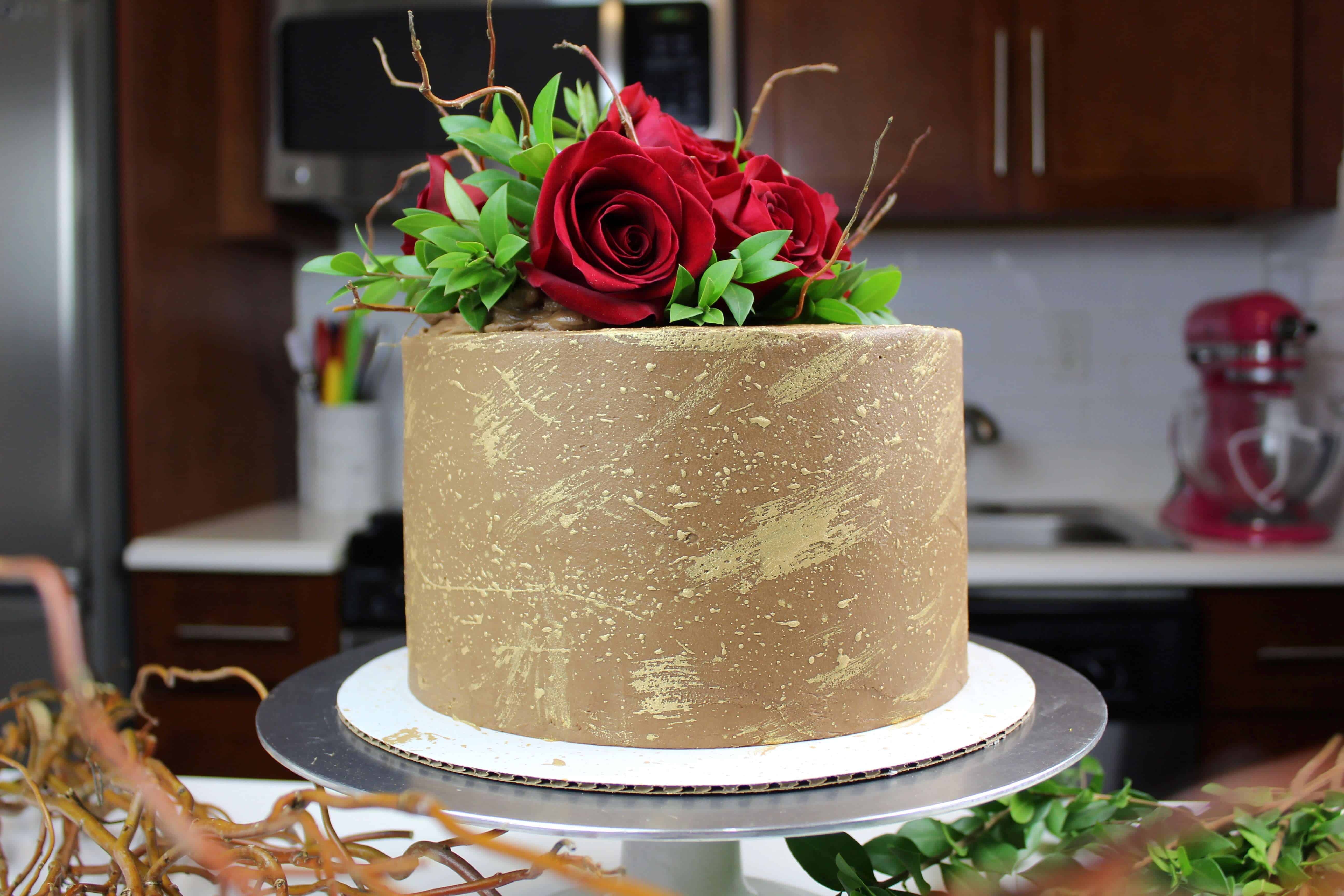 巧克力订婚蛋糕饰以可食用黄金和鲜玫瑰照片