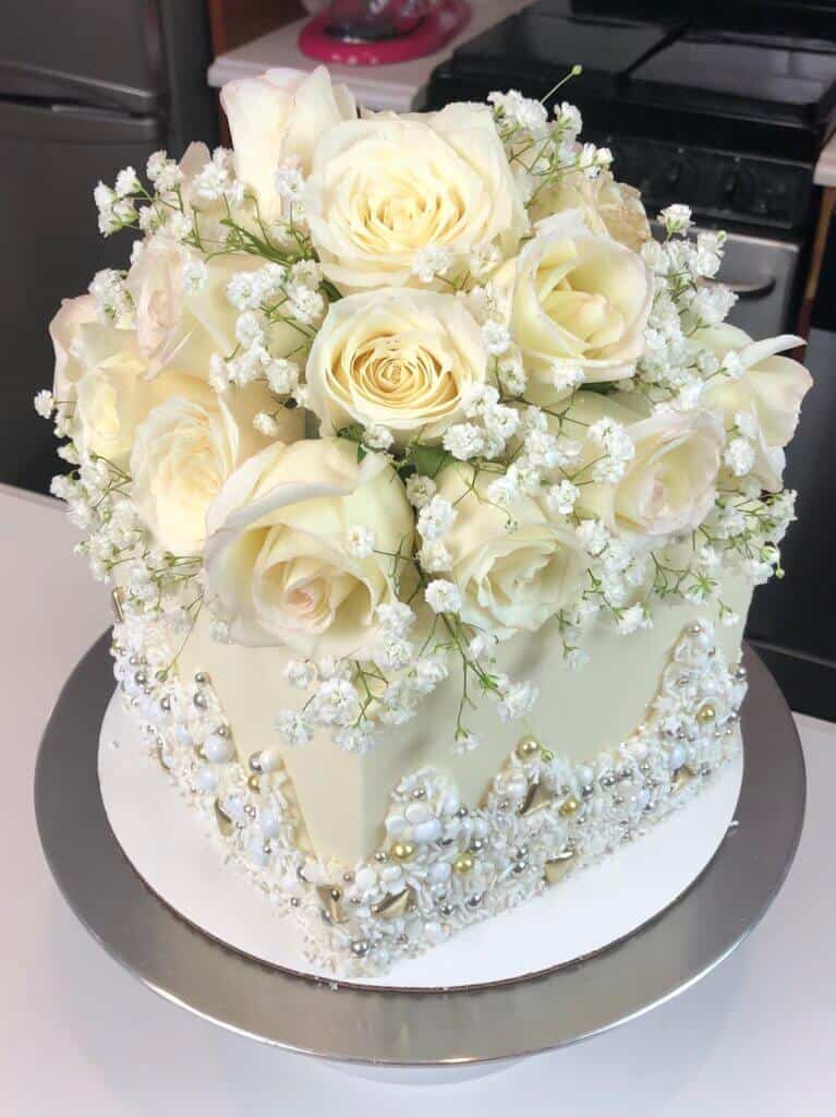 用玫瑰装饰的白色订婚蛋糕照片