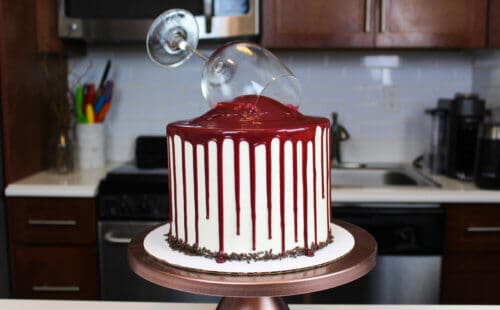 红巧克力蛋糕，上面有红酒滴，放在铜蛋糕架上