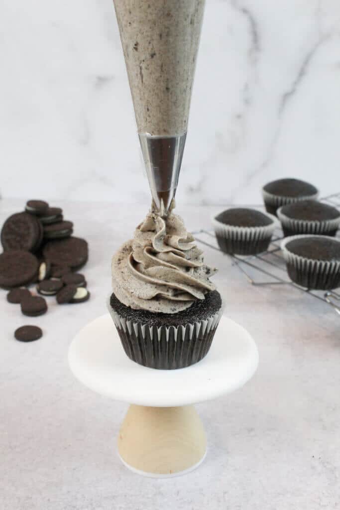 将奥利奥奶油涂在巧克力纸杯蛋糕上，加100万威尔顿巧克力