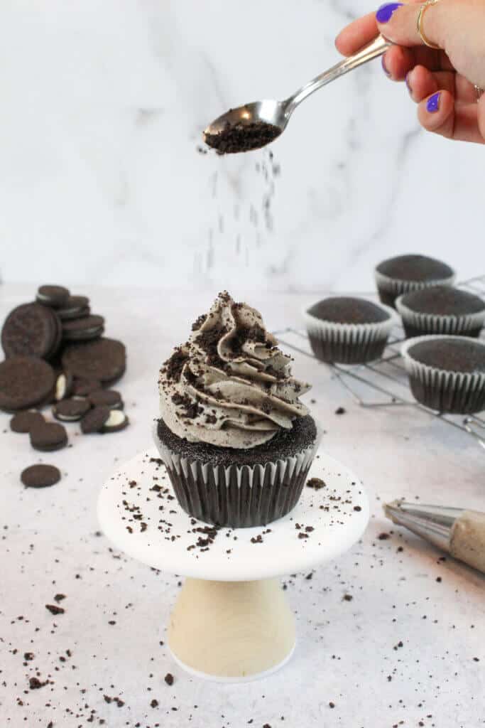 将碾碎的奥利奥洒在巧克力奥利奥纸杯蛋糕上