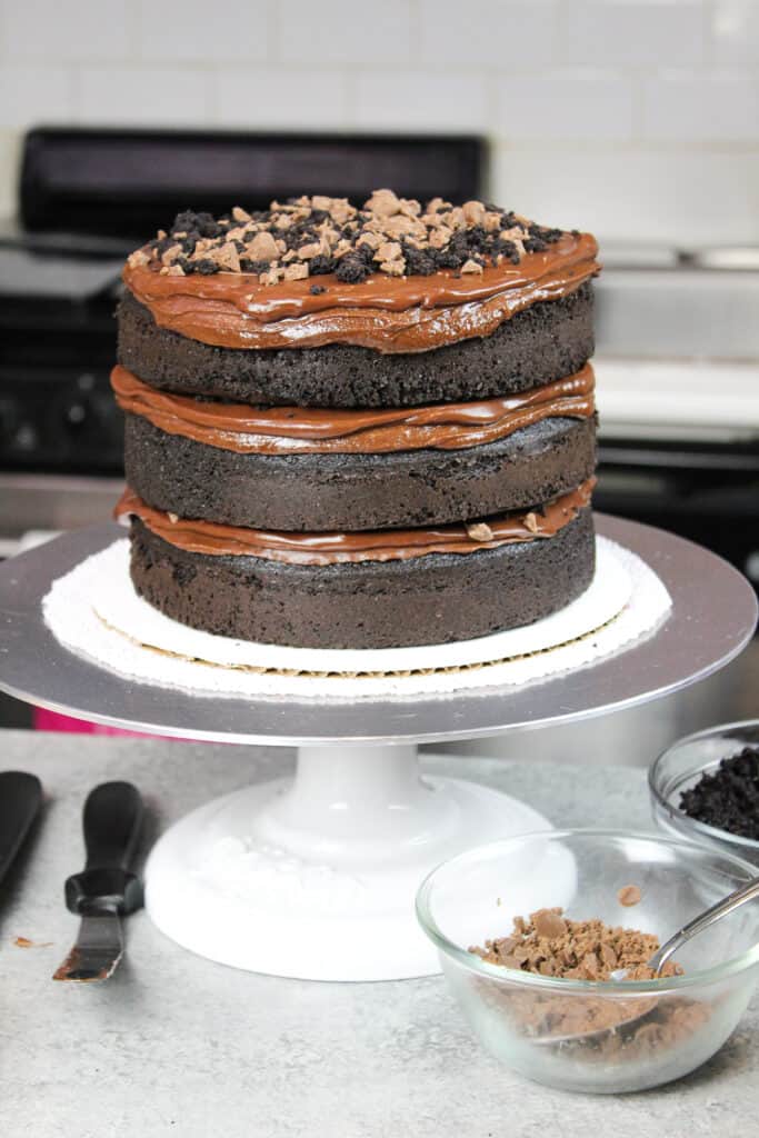 image of stacked chocolate cake layers with chocolate ganache frosting and pudding filling