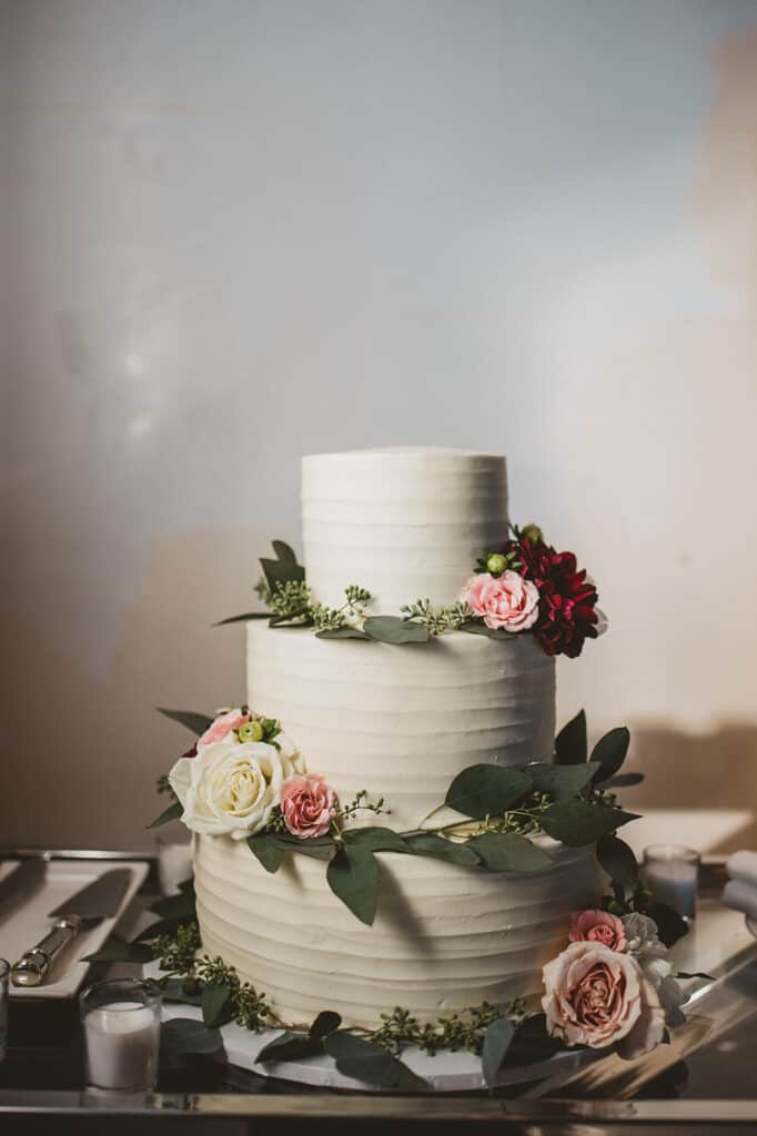 image of a simple rustic wedding cake decorated with fresh flowers