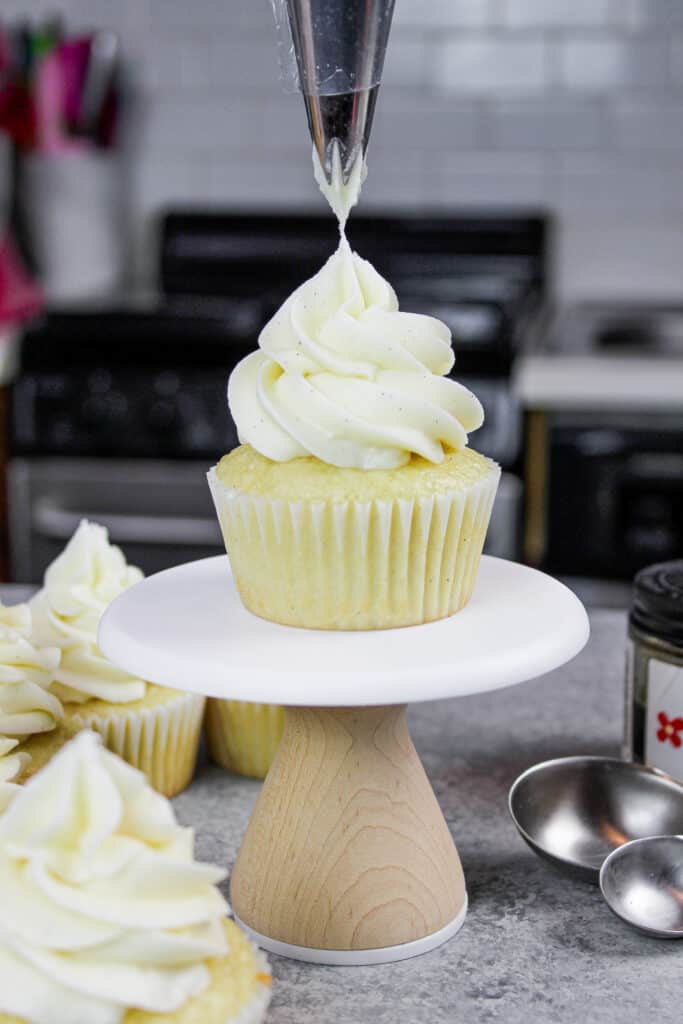 image of gluten free vanilla cupcake being frosted with vanilla bean buttercream frosting