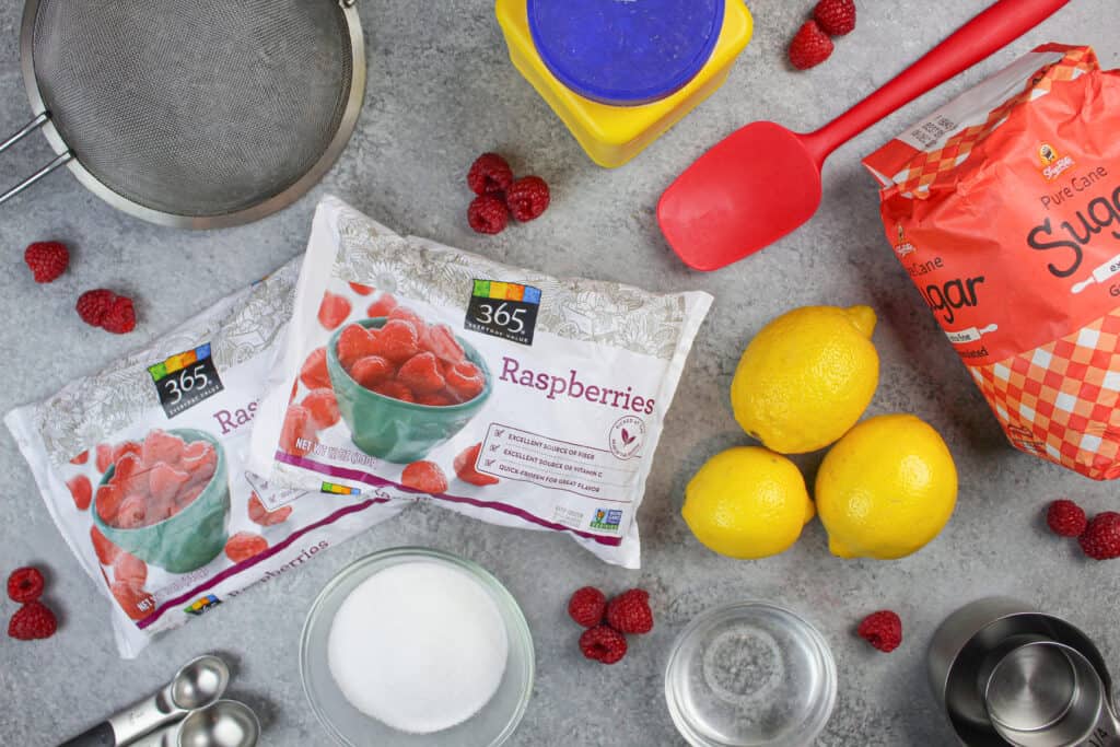 此覆盆子蛋糕馅料中使用的成分图像，包括冷冻覆盆子、糖和柠檬汁