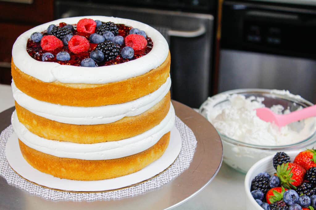 混合浆果馅的蛋糕层和mascarbone奶油干酪的管道结霜坝的图像