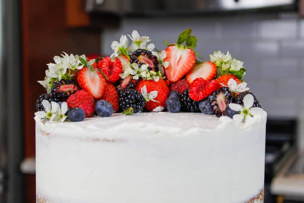 装饰着新鲜的浆果和食用花卉的春天和复活节蛋糕的顶部的图像