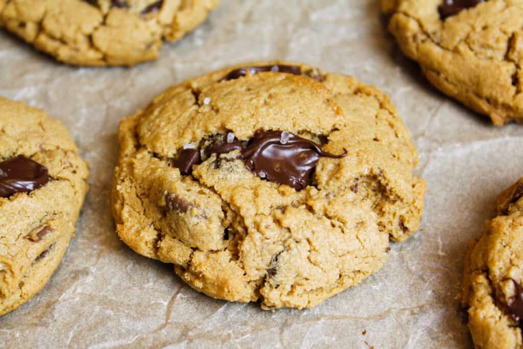 image of peanut butter chocolate chip cookie on parchment paper sprinkled with sea salt