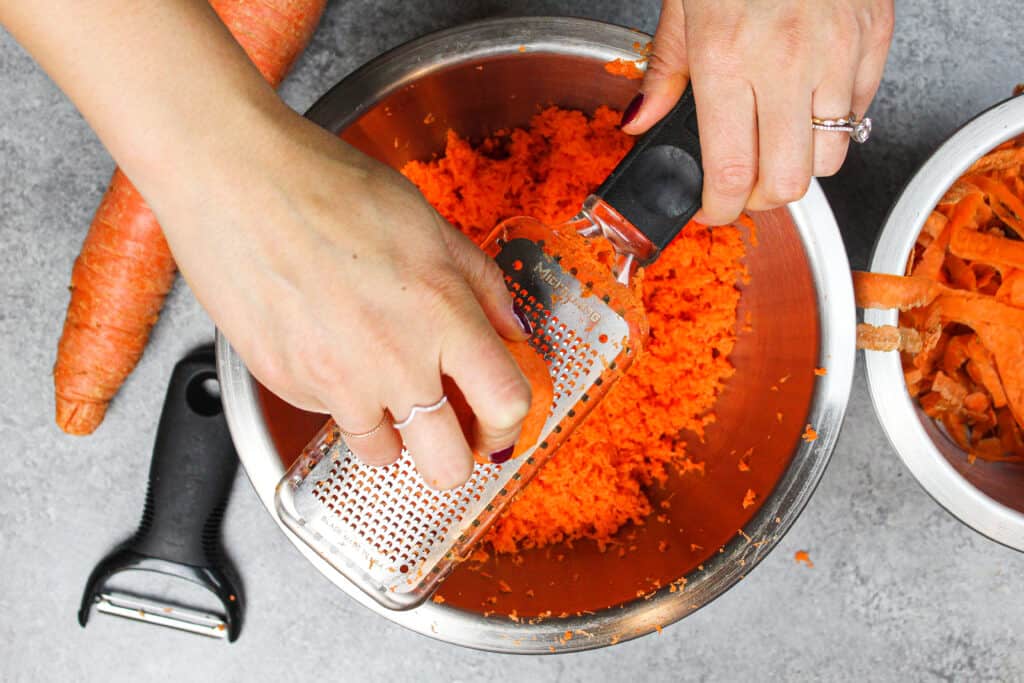 胡萝卜蛋糕配方的微型平面磨床上磨碎胡萝卜的图像