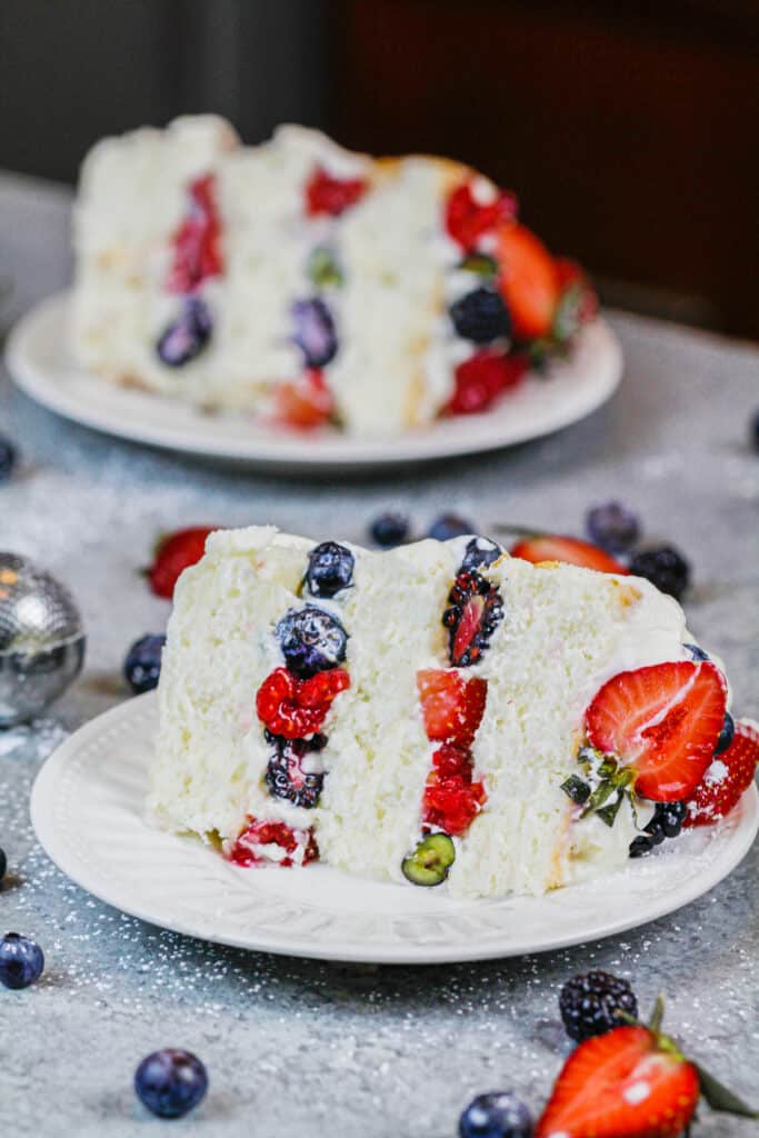 分层天使蛋糕馅新鲜浆果切片的图像和奶油糖霜