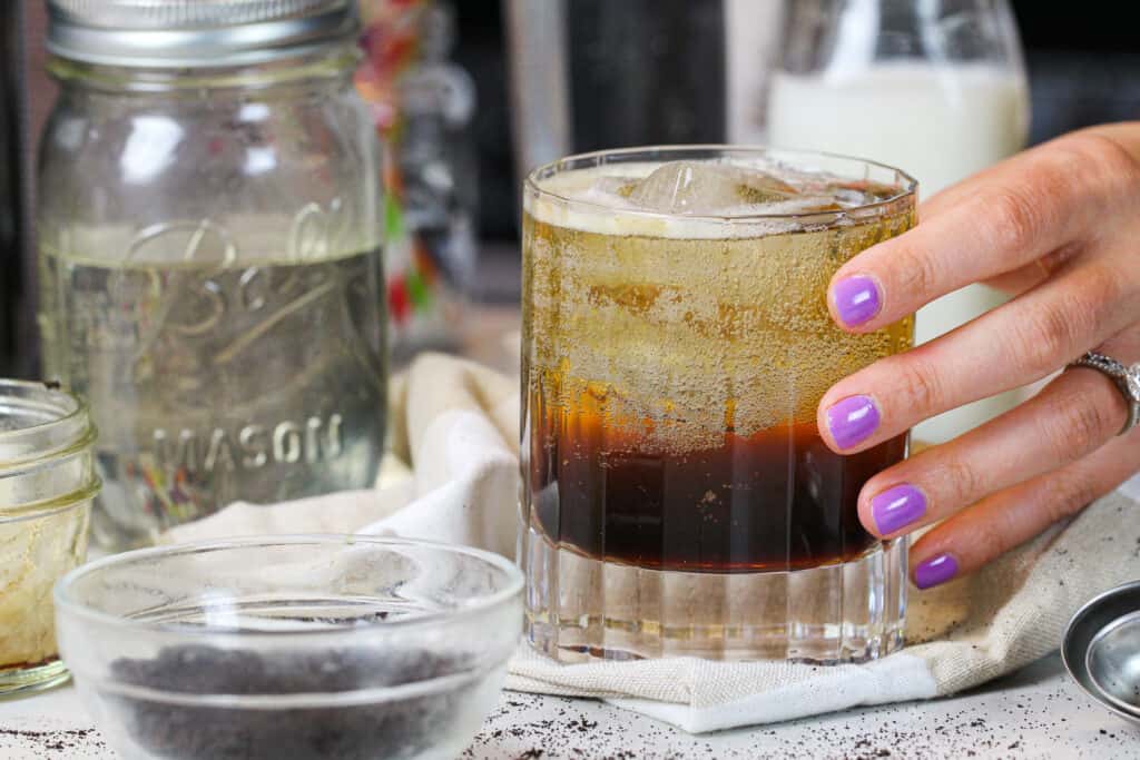 抓住新近地制造的浓咖啡苏打的手的图象作为下午拾起享受