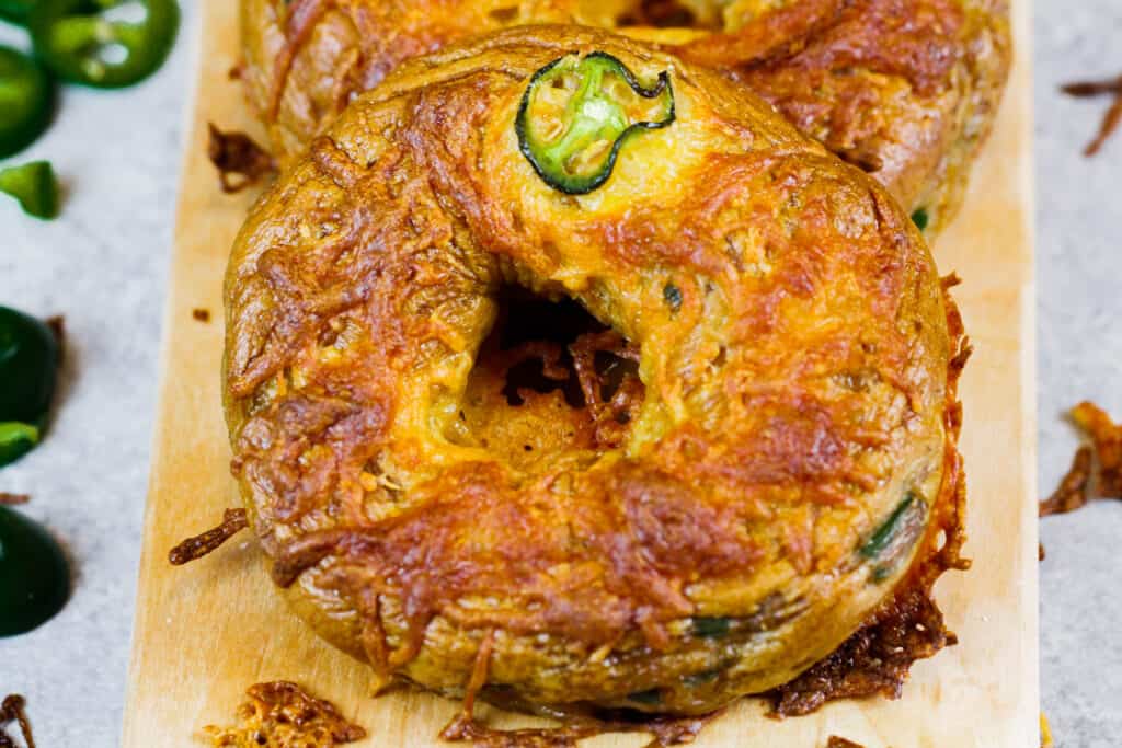 Jalapeno Cheddar百吉卷的图象在委员会的，准备被剪切和吃