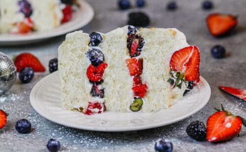 图像的分层天使食品蛋糕充满浆果和稳定的生奶油