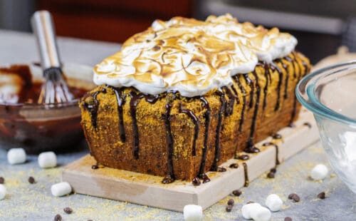 用巧克力毛毛雨装饰的味道香蕉面包和烤蛋白软糖顶部的图象