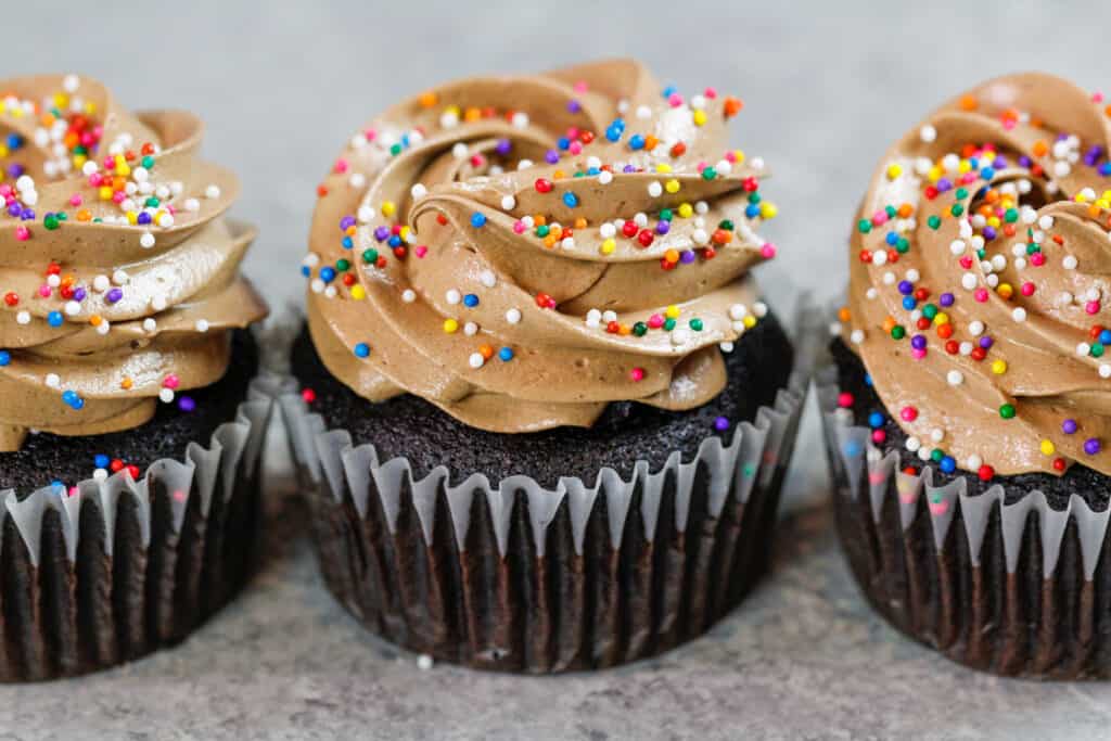 巧克力意大利蛋白酥皮乳酪乳脂霜的图象在杯形蛋糕顶部