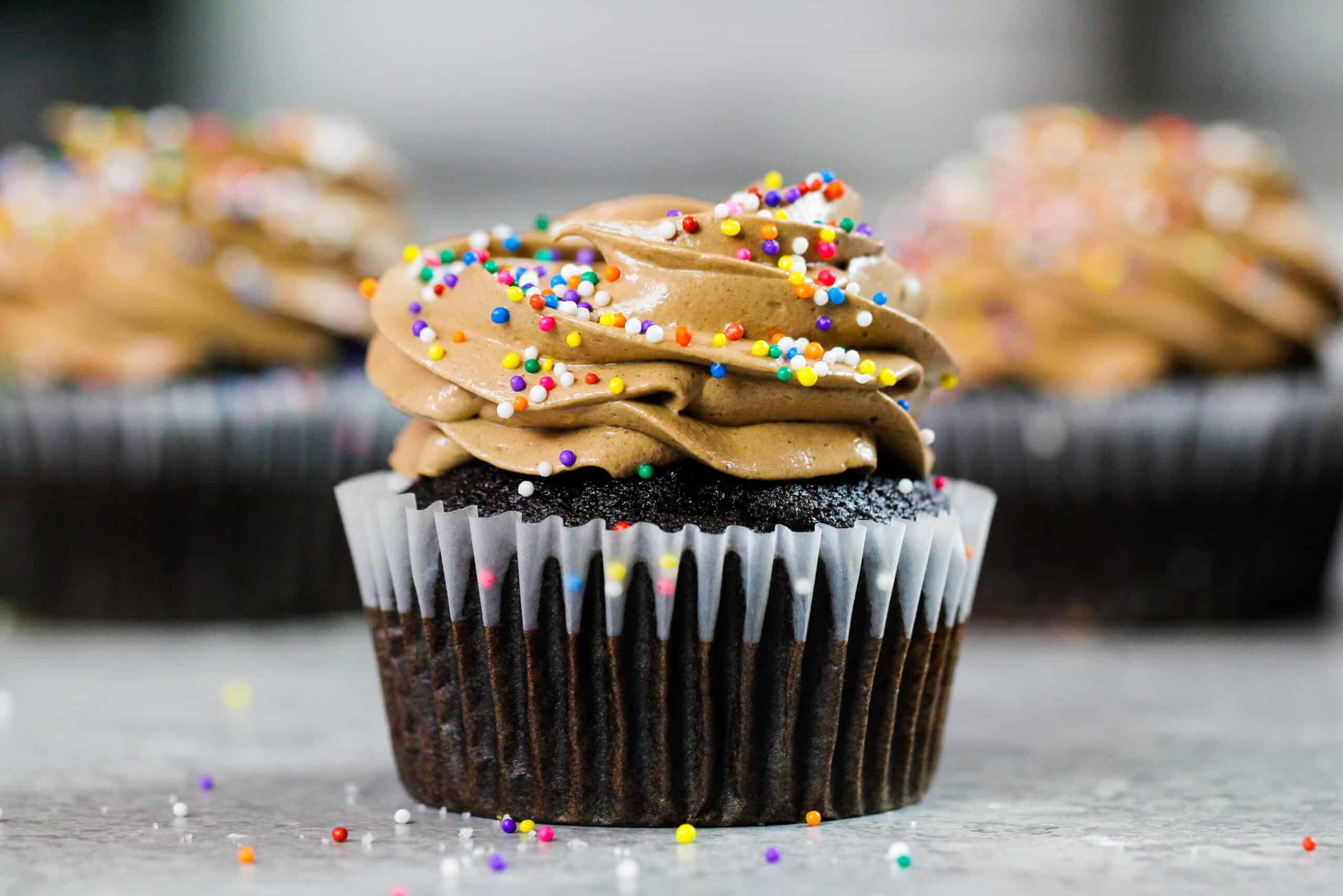 巧克力意大利蛋白酥皮乳酪乳酪的图象在巧克力杯形蛋糕顶部结霜