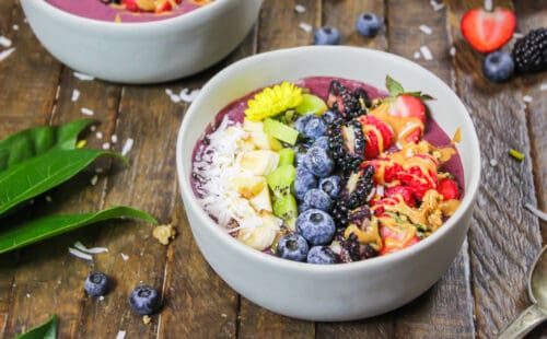 一个阿萨伊碗的形象与花生酱和装饰用新鲜水果，麦片和一些食用花卉制成