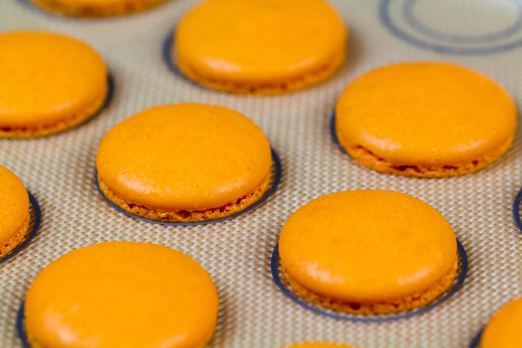 橙色macaron壳的图象烘烤在硅砾席子和冷却