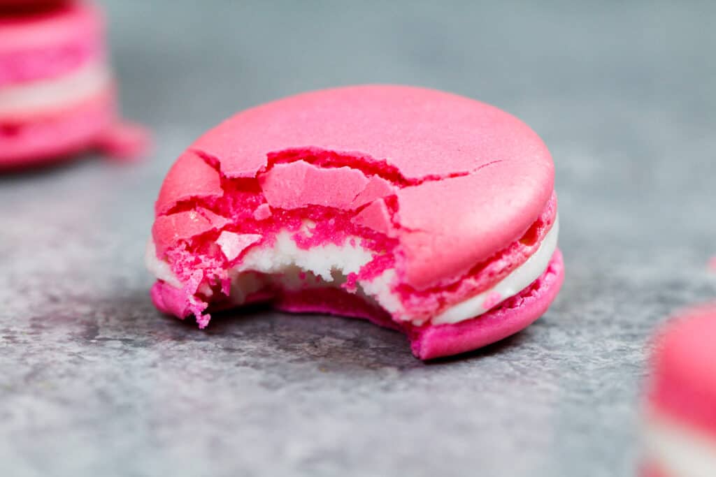 法国马卡龙被咬了一口，显示出嚼劲十足的中心和脆脆的外壳