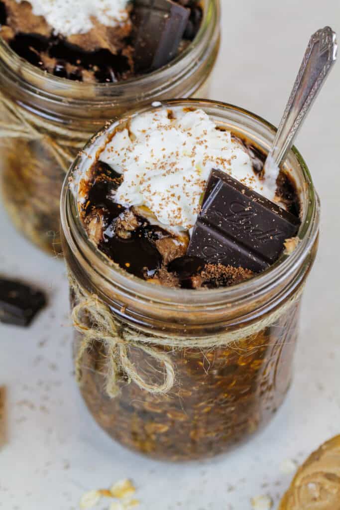 image of chocolate overnight oats topped with whipped cream and a piece of chocolate