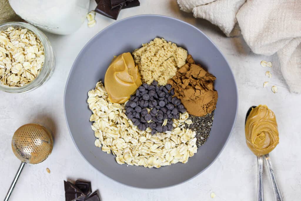 image of ingredients in a bowl to make chocolate peanut butter overnight oats