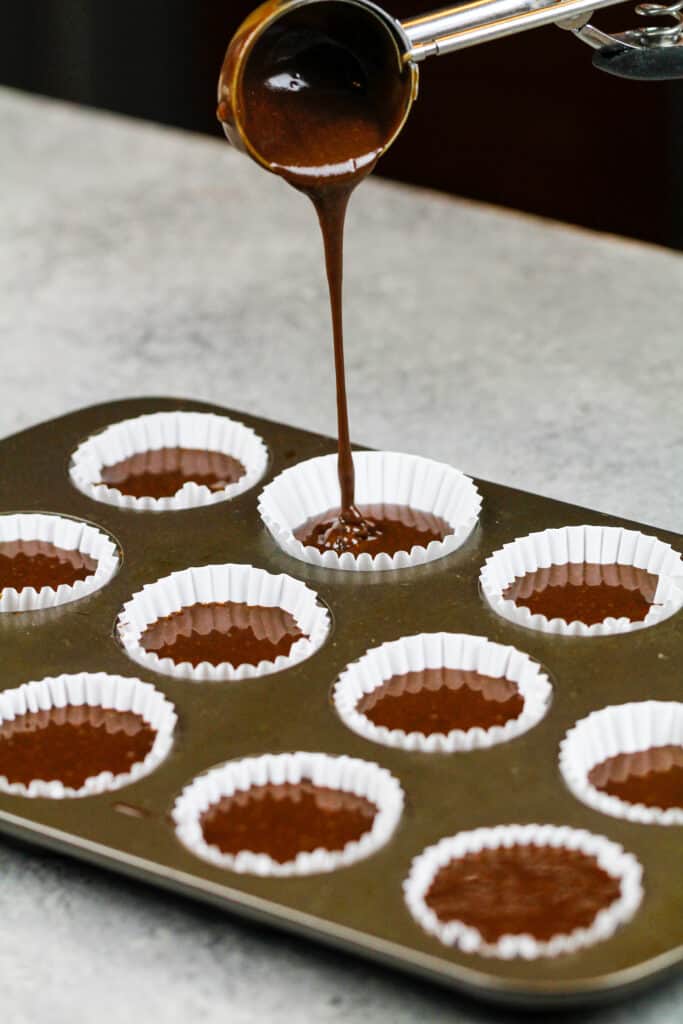 迷你杯形蛋糕衬垫的图象充满巧克力杯形蛋糕面糊