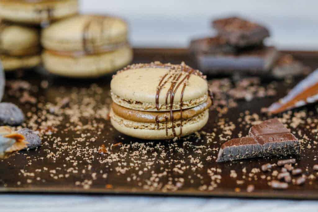 用熔化巧克力装饰的法国巧克力macarons的图象熔化巧克力