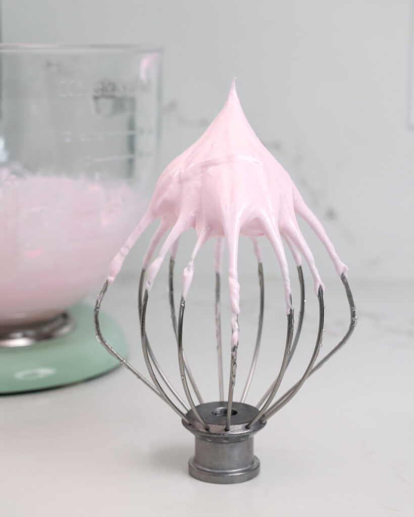 粉红色的意大利蛋白甜饼的图像被鞭打成硬峰