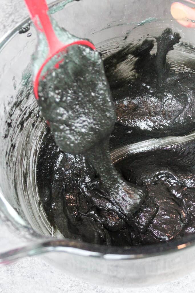 黑色马卡龙面糊的图像，已经混合到完美的稠度