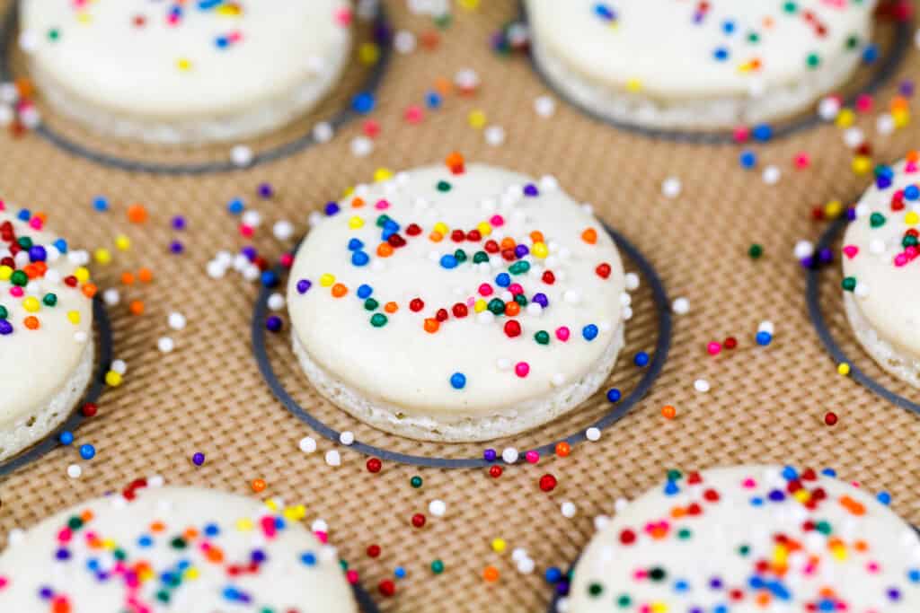 烘烤的白色macaron壳的图象冠上与非pareil洒制作彩虹macarons