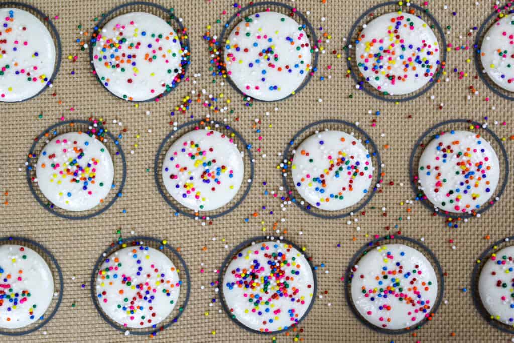 在烤之前，白色马卡龙的外壳上点缀着彩虹