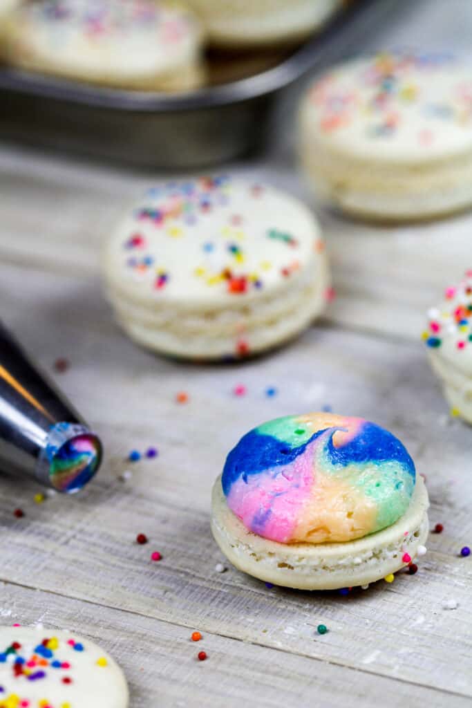 彩虹马卡龙的图像，彩虹奶油，准备与它的第二马卡龙外壳