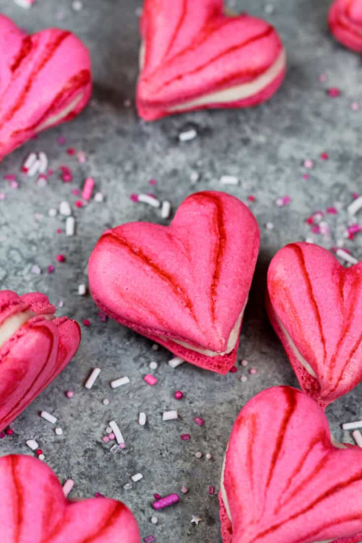 粉红色心形的马卡龙的图像，里面装满了奶油