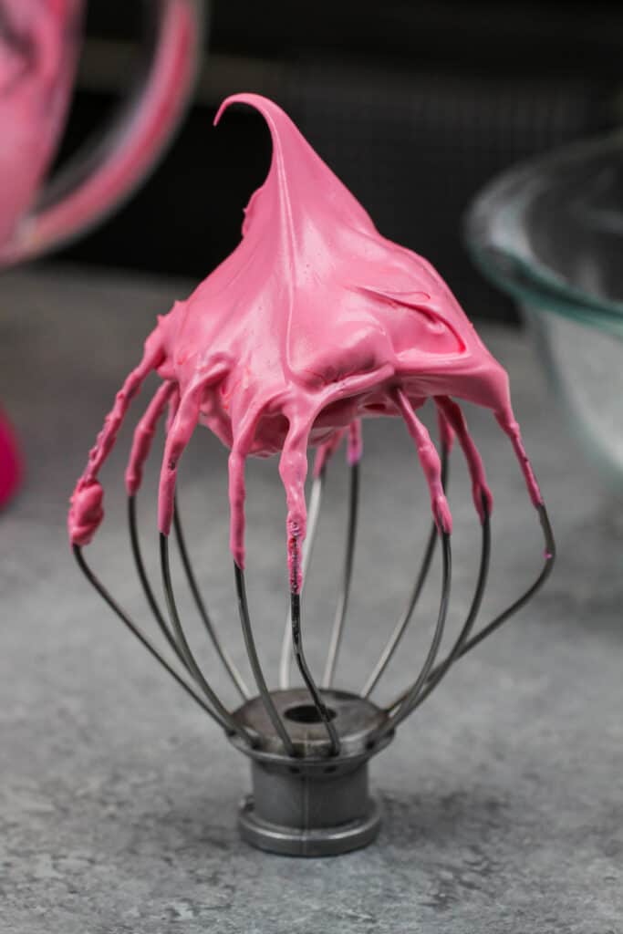 法式蛋白甜饼的图像，粉红色涂有凝胶食用色素以制成覆盆子马卡龙