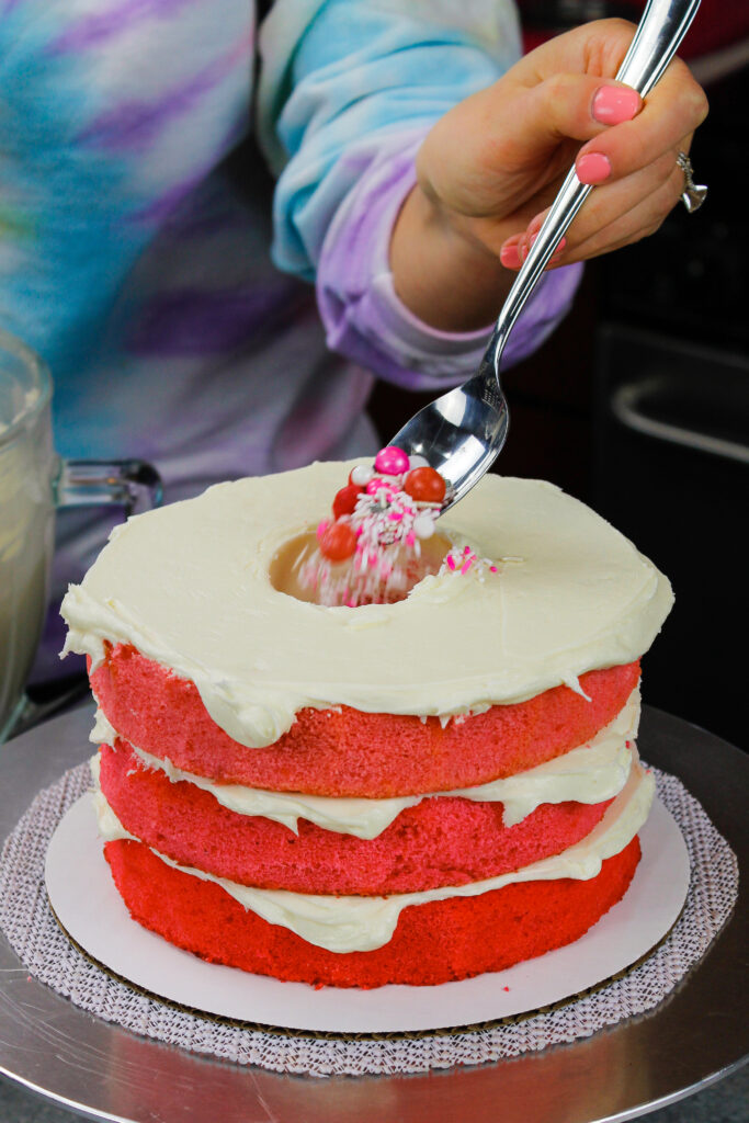 这是一个蓝色的蛋糕，里面装满了粉色的糖果和糖屑