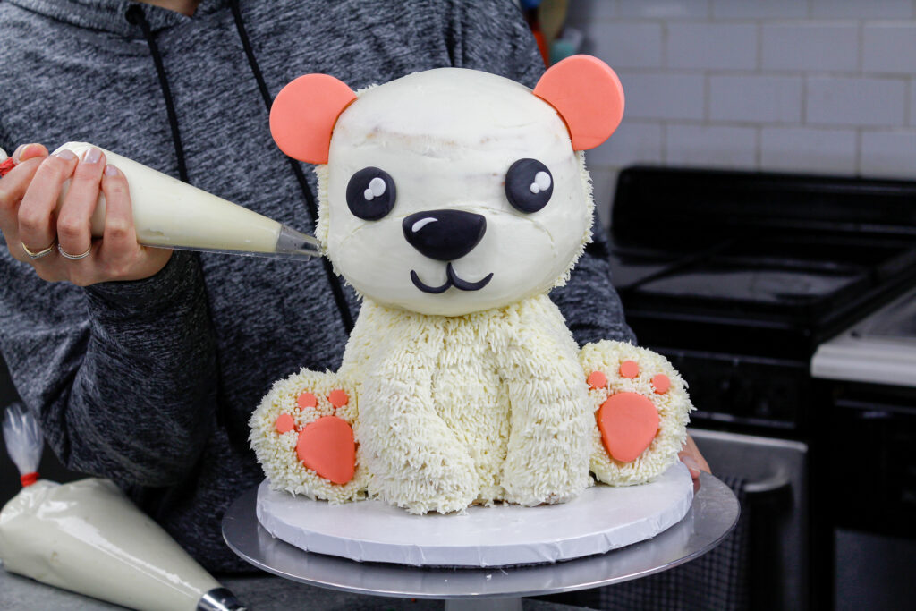 北极熊蛋糕被用小草尖覆盖在奶油皮草上