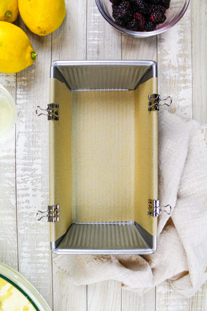 用非棍子喷雾润滑的大面包锅的图象并排列了用金属粘合剂夹子固定的羊皮纸吊索