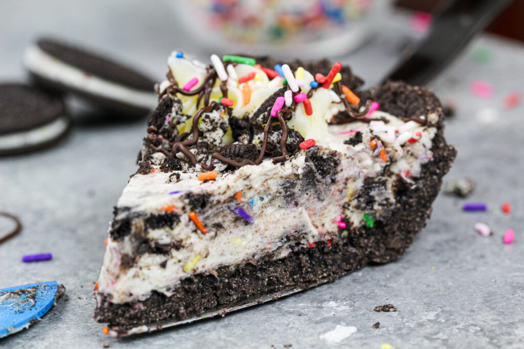 用洒和巧克力毛毛装饰的一块切片的图象奥利奥奶油饼