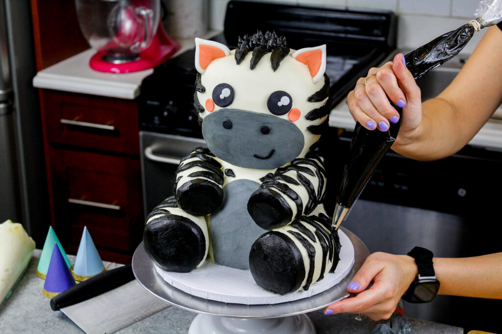 黑乳卷霜镶边条纹的图象被用在一个可爱的小斑马蛋糕上为生日聚会做了