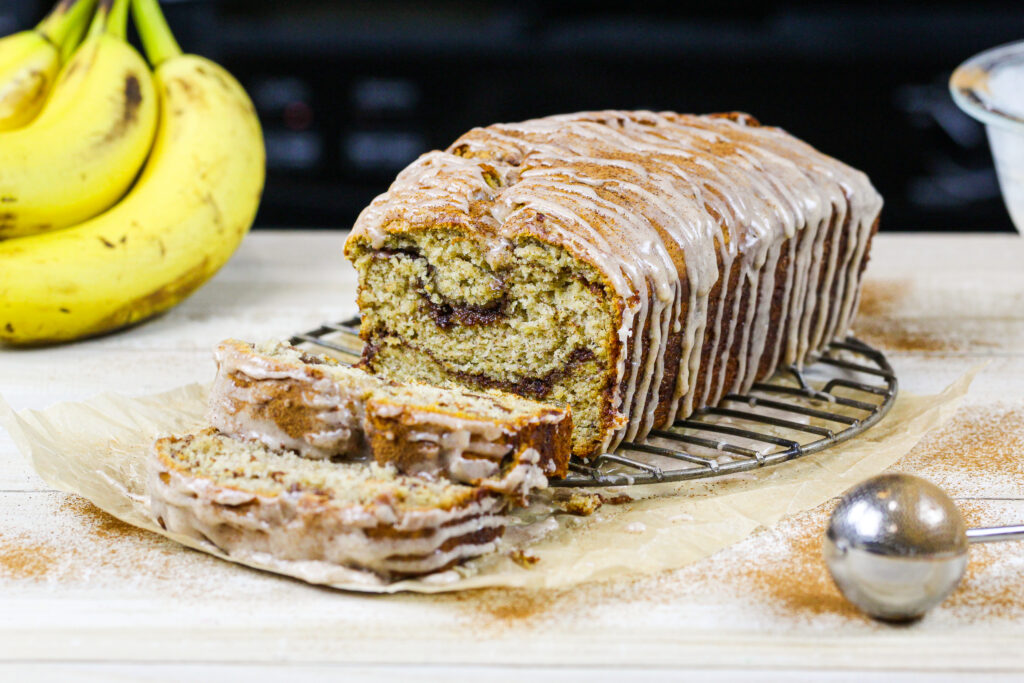 肉桂漩涡香蕉面包的图片，被切成薄片，展示了它美丽的肉桂糖漩涡