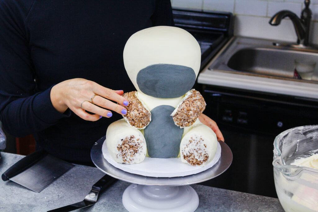 装饰米花的蛋糕被加到斑马蛋糕上，做成了它的腿和胳膊