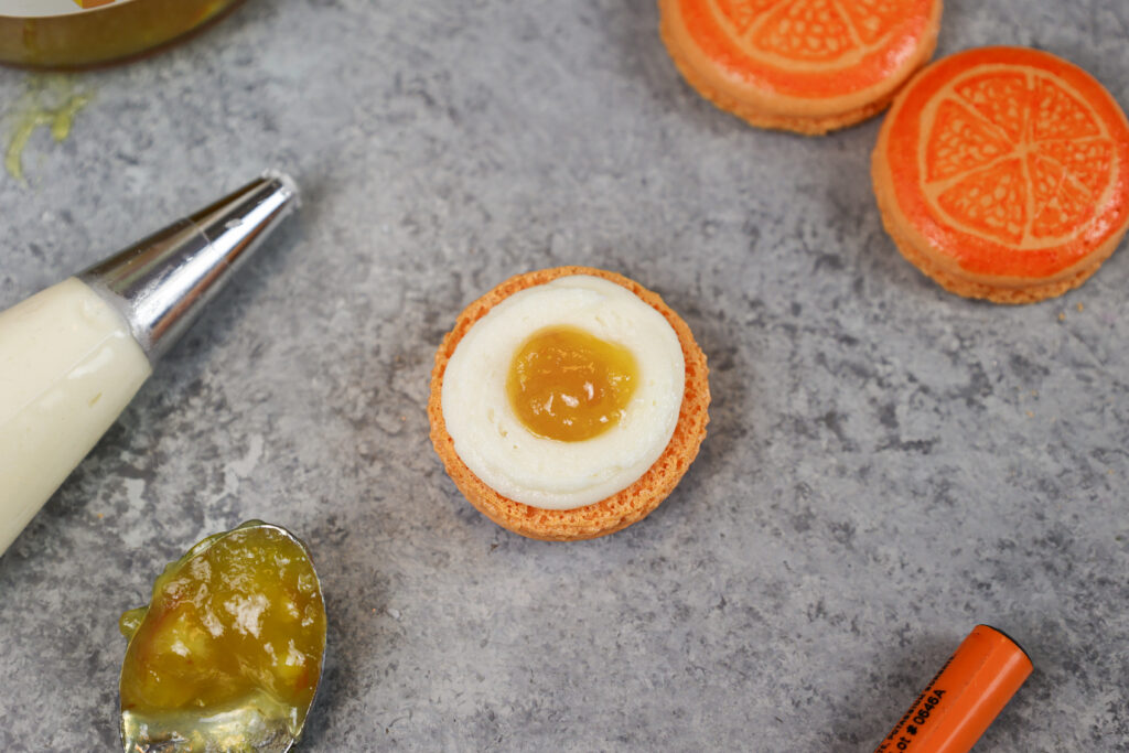 这是一个充满橘子酱和美国奶油的橘子马卡龙的形象