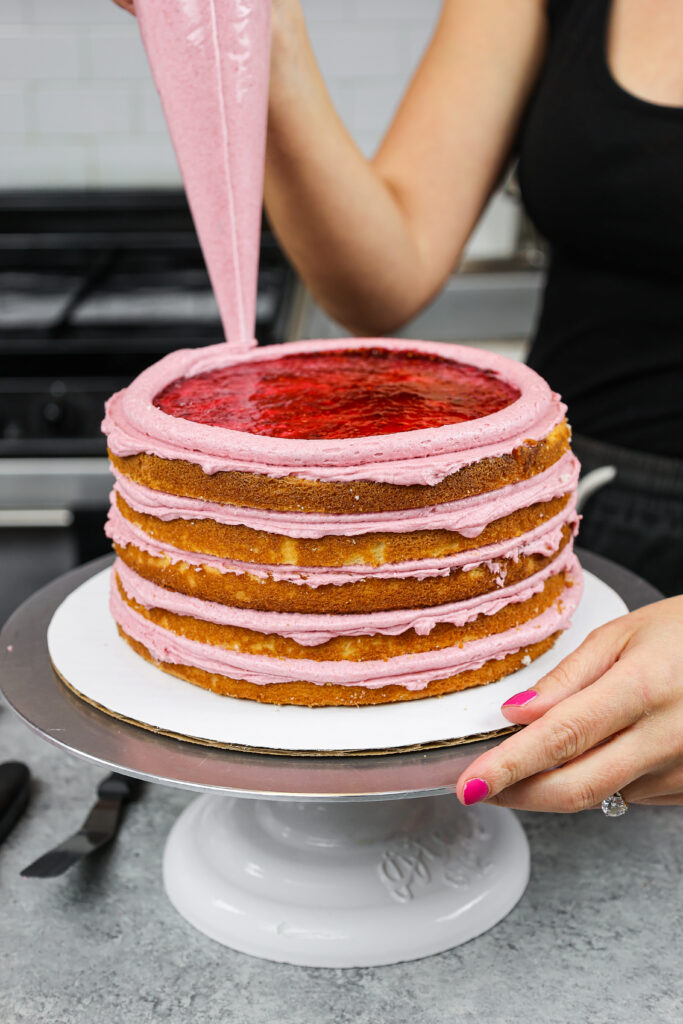 一个蛋糕被一圈糖霜包围着，上面填满了覆盆子果酱