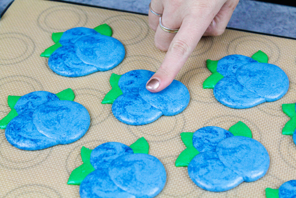 被用管道的蓝莓形状的macarons的图象在被烘烤之前形成皮肤