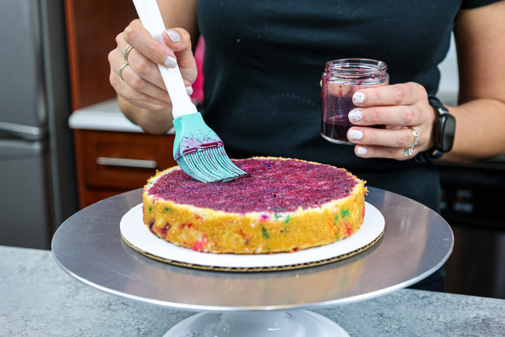 蓝莓简单的糖浆的图象被刷在蛋糕层数