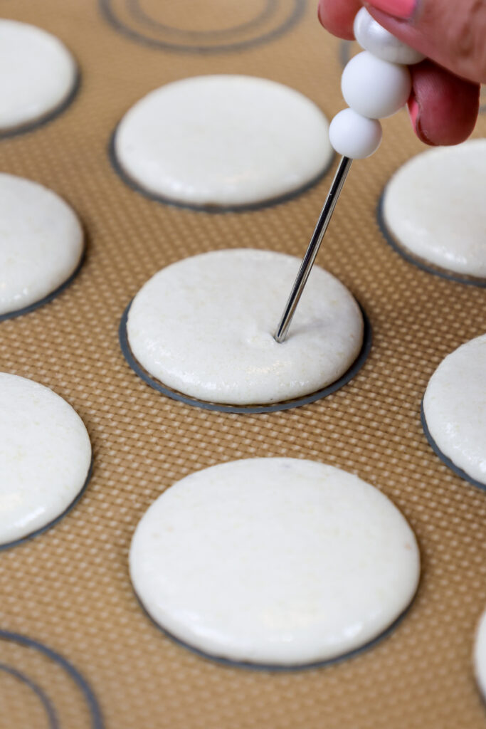 被被撞击的白色香草macaron壳的图象被击开的柜台释放气泡并且都有任何气泡被划线突然浮出水面