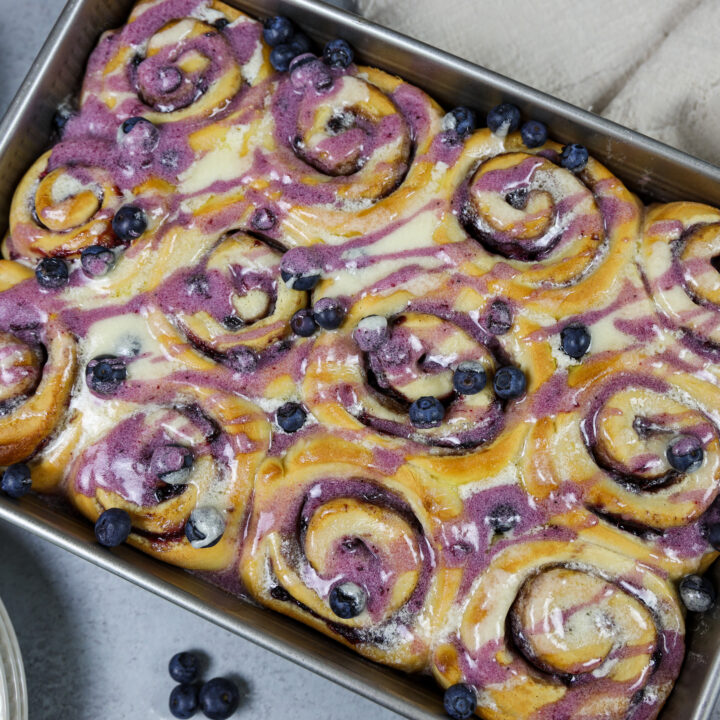 蓝莓肉桂卷,烤的形象,与香草和蓝莓釉下毛毛雨
