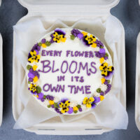 一个可爱的便当蛋糕或午餐盒蛋糕装饰着可爱的格言和可食用的花朵