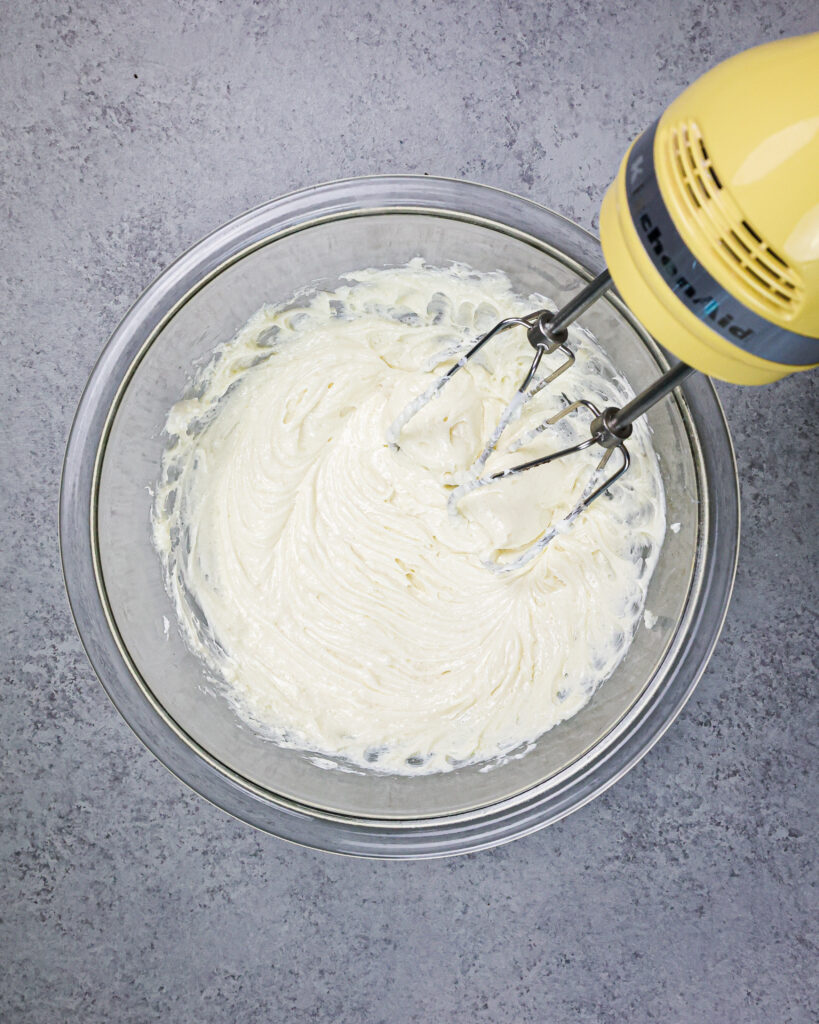 芝士蛋糕馅的图像与手工混合器混合