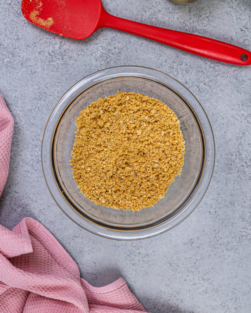 图像的全麦饼干和黄油混合物被用来装饰没有烤芝士蛋糕